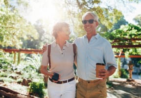 a man and a woman standing next to each other holding coffee at Vibe Apartments at Arbour Lake, Alberta