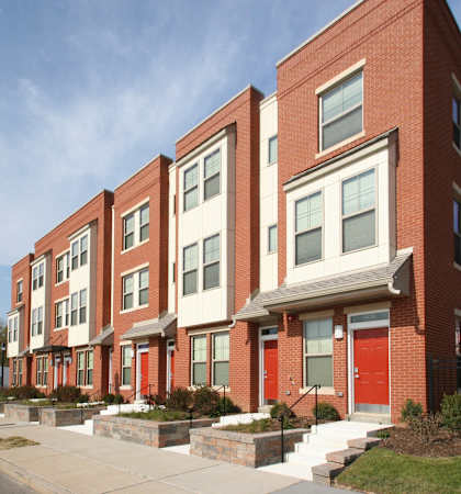 a row of brick apartment buildings with red doors