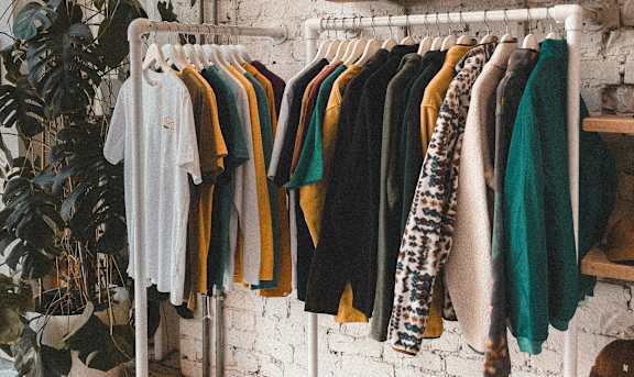Clothes hanging on a rack in a room.