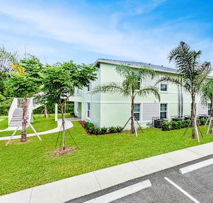 a large white building with palm trees in front of it