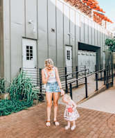 A woman and a child are standing in front of a building.