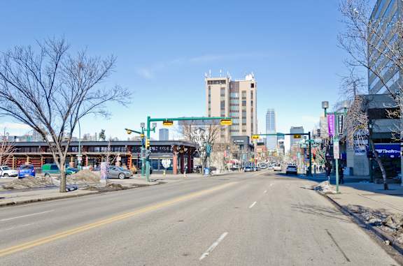 A city street with a clear blue sky and buildings in the background.