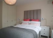 Thumbnail 3 of 3 - a bedroom with a bed and red pillows