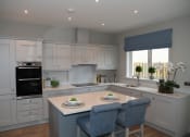 Thumbnail 1 of 3 - a contemporary kitchen with white cabinets and a white island with blue chairs