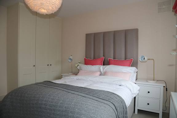 a bedroom with a bed and red pillows