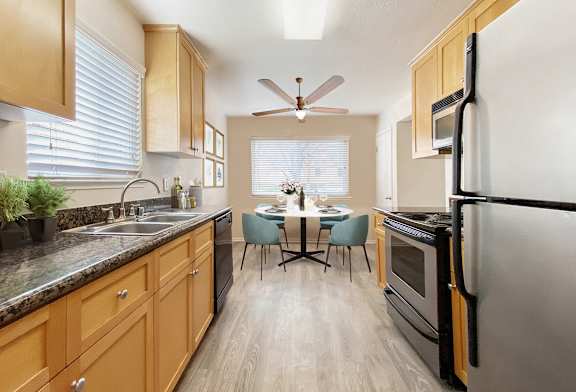 A kitchen with wooden cabinets and a black refrigerator.