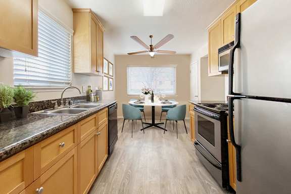 A kitchen with wooden cabinets and a black refrigerator.
