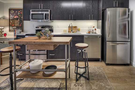 a kitchen with stainless steel appliances and a wooden table