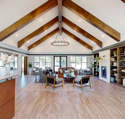 a dining room with a table and chairs in a large room with vaulted ceilings