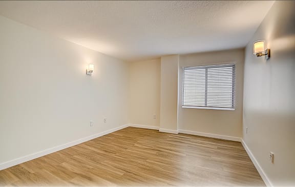 an empty living room with wood floors and a window  at Palm Gardens @ Biscayne Gardens, North Miami, FL