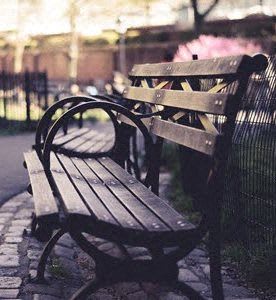 a wooden bench sitting next to a fence