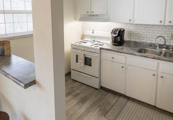 This is a photo of the kitchen and breakfast bar of the 1 bedroom, 631 square foot model apartment at Lake of the Woods Apartments in Cincinnati, OH.