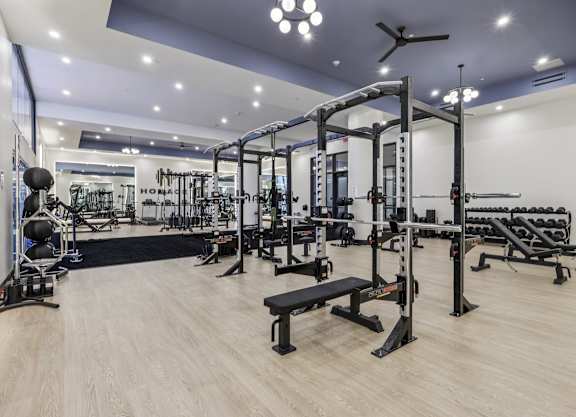 A gym with a variety of equipment including weights and weight machines. at LiveWell Apartments, Pittsburgh, PA, 15222