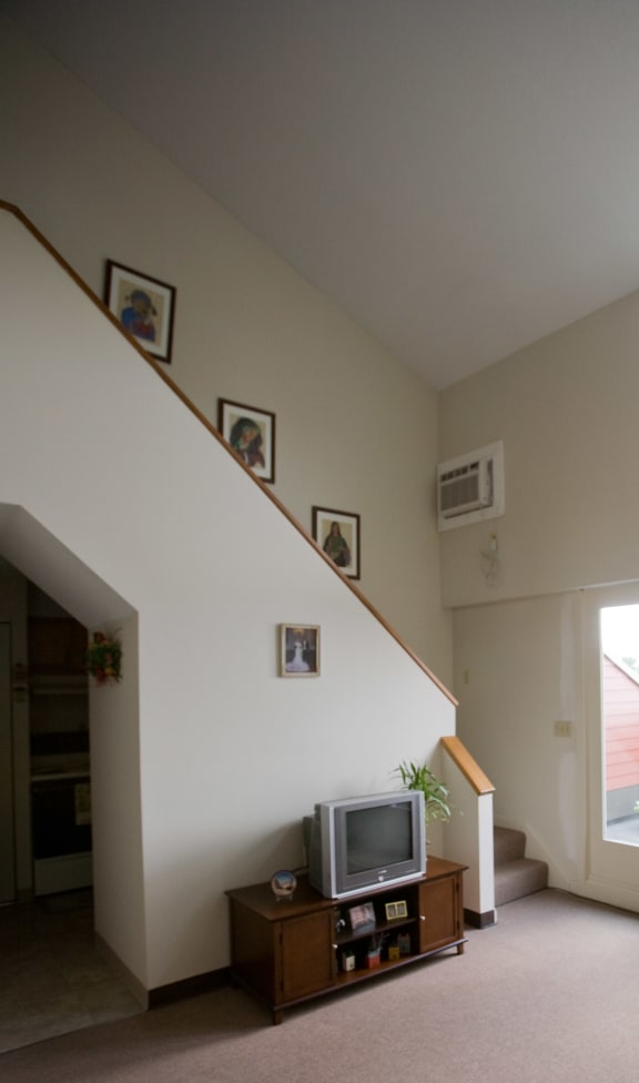 a living room with a tv and a staircase