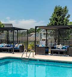 A pool with a black fence and a black umbrella.