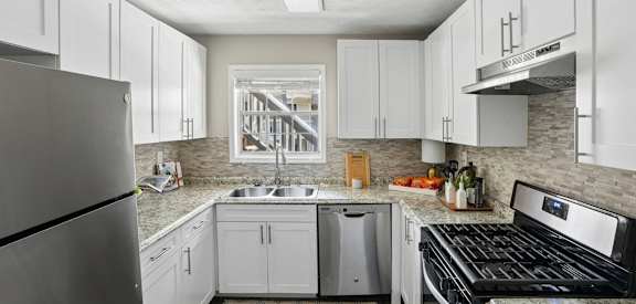 A kitchen with white cabinets and a black stove top oven.