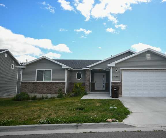 a gray house with a driveway and a garage door