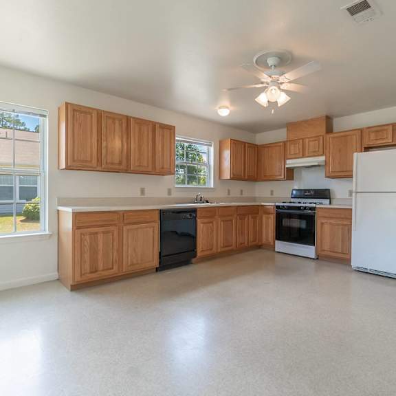 an empty kitchen with wooden cabinets and a white refrigerator at Huntington Village **, Warner Robins, 31098