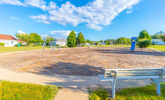 a park bench sitting in front of a playground at Huntington Village **, Warner Robins, Georgia