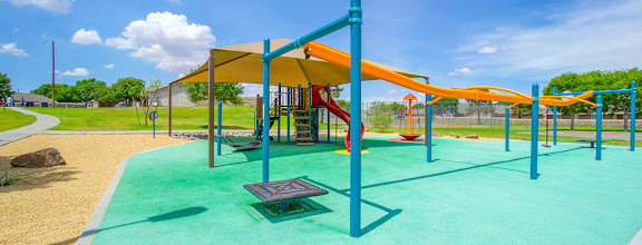 a playground with a yellow and blue swing set