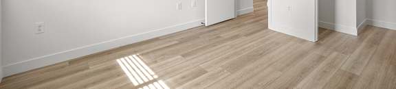 an empty living room with white walls and wood flooring