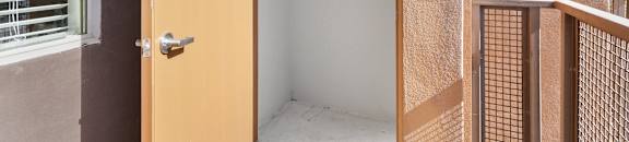 an open door to a small closet in the corner of a house