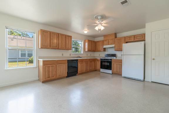 an empty kitchen with wooden cabinets and a white refrigerator at Huntington Village **, Georgia