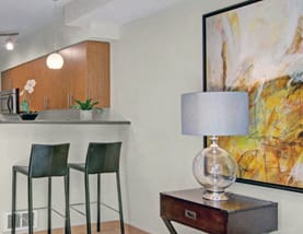 Part of the living room at 4Marq and a bar counter with bar stools. 