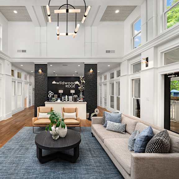 A living room with a couch, coffee table, and a large window.