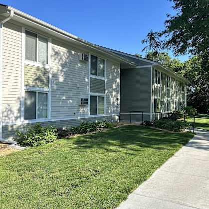 a gray house with a sidewalk in front of it
