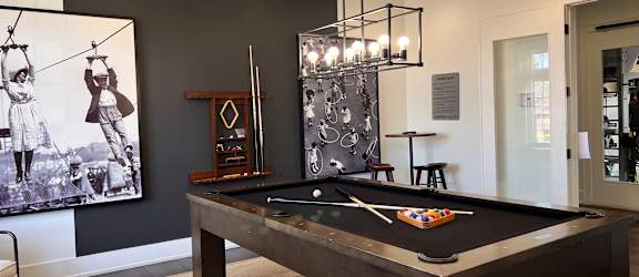 a billiards table in a game room with a painting on the wall