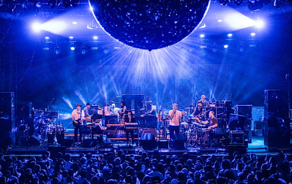 A band performing on stage with blue lighting.