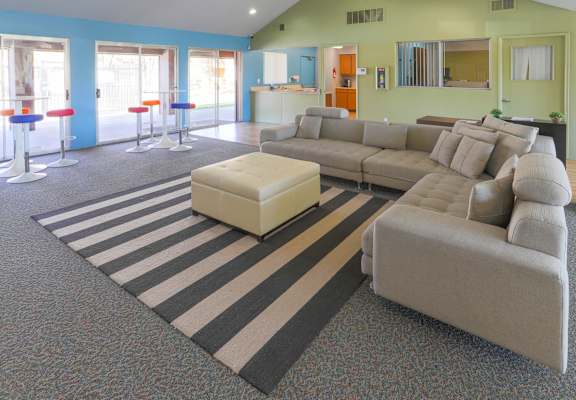 A living room with a grey sofa and a white ottoman.
