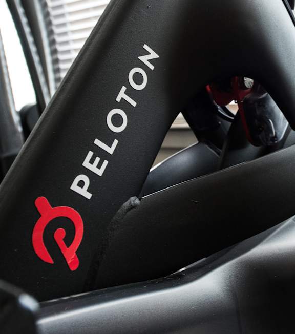 Peloton logo on a black bicycle seat.