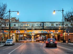 a train on a bridge over a street