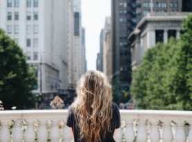a woman with long hair standing on a bridge
