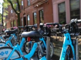 a row of blue bikes parked in front of a building