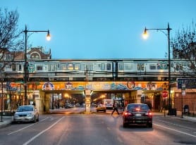 a train on a bridge over a street