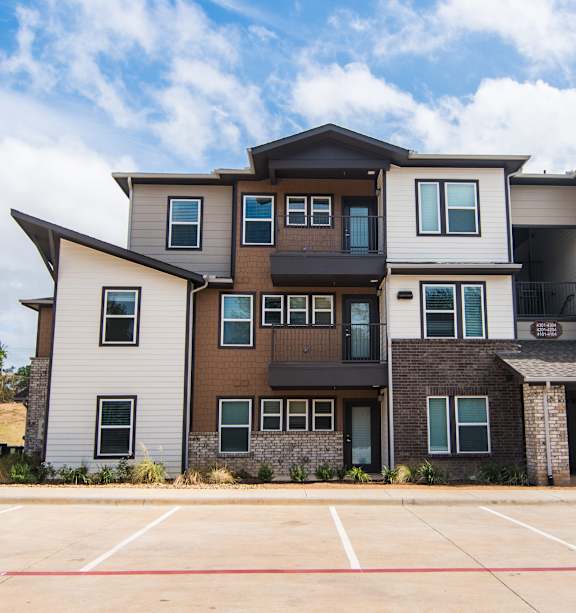 Apartment building with a car parked in front.