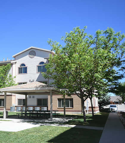 a house with a yard and trees in front of it