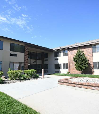 an exterior view of an apartment building with a sidewalk and grass