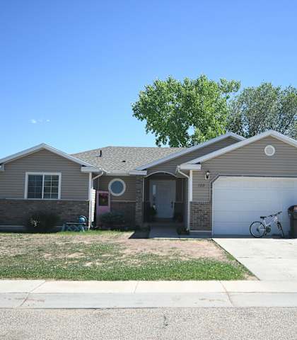 a tan house with a white garage door