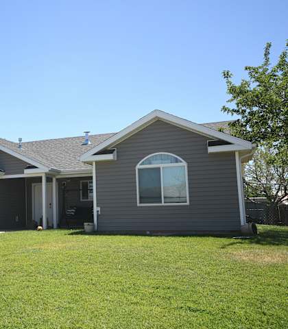 a gray house with a lawn and a garage
