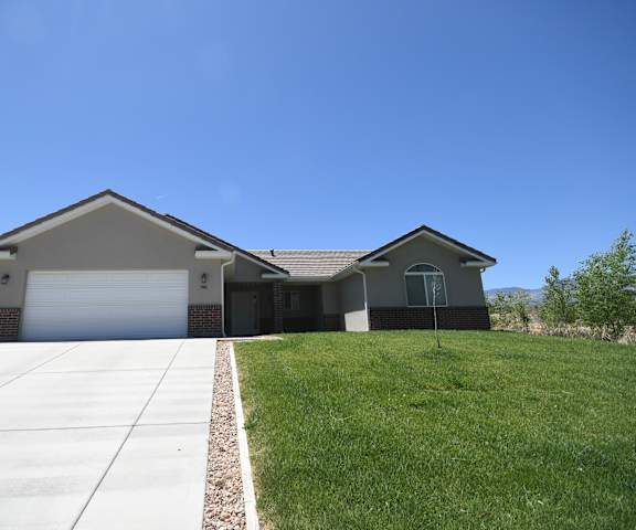 a house with a driveway and lawn in front of it