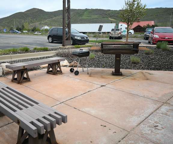 two benches sitting on a sidewalk next to a parking lot
