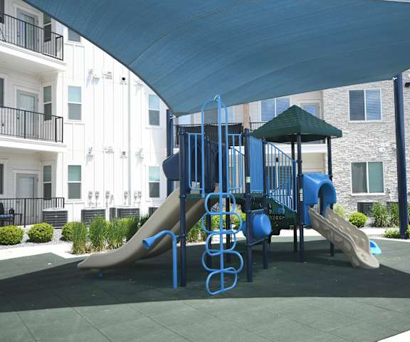 a playground at an apartment complex with a blue canopy over it