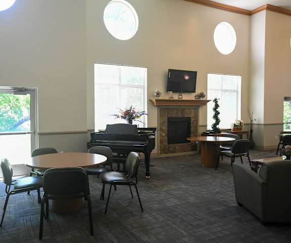 a living room with tables and chairs and a piano