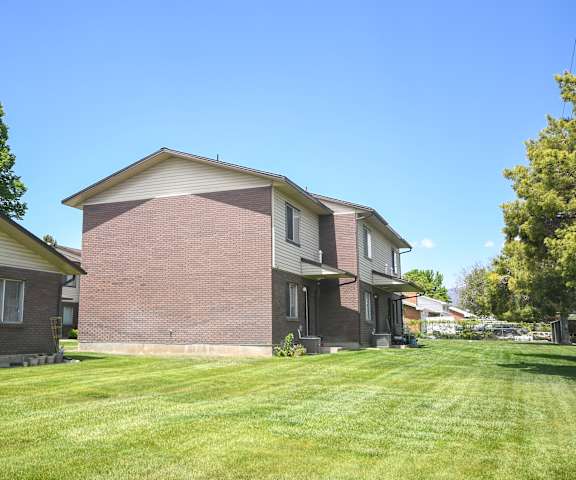 a brick house with a yard in front of it