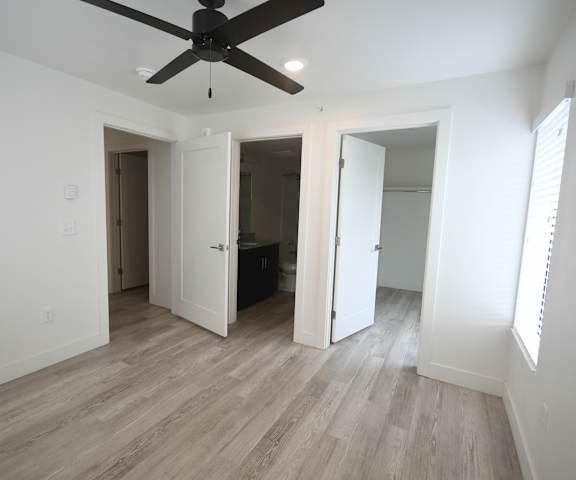 an empty living room with white walls and a ceiling fan