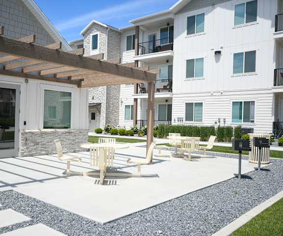 a patio with tables and chairs in front of a building